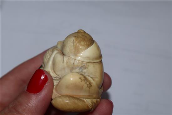 A Japanese Meiji period carved ivory netsuke of a fox cub on a cushion, with inset eyes 3.5cm high